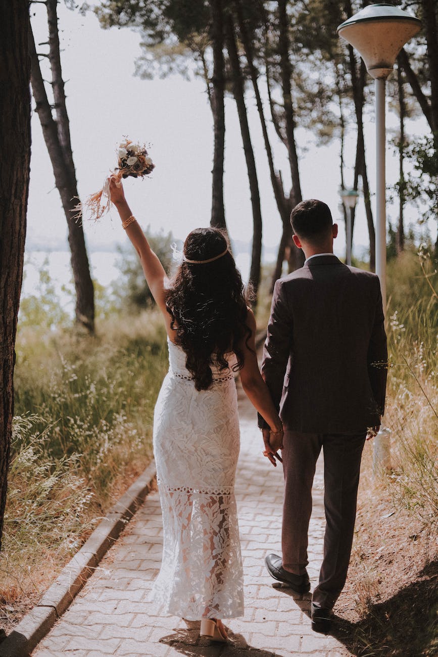 photo of couple walking on paved pathway